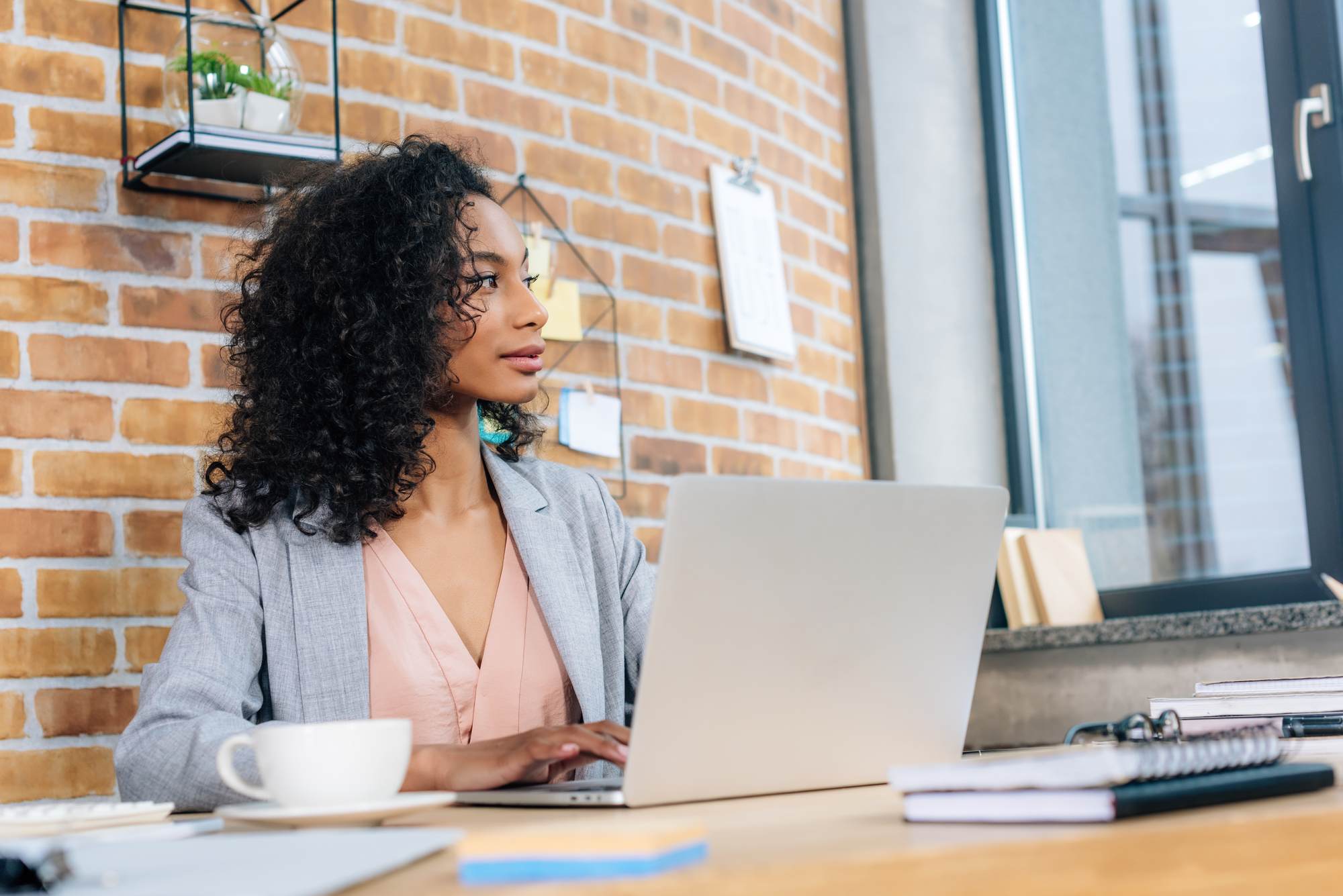 African american Casual businesswoman sitting at office desk with laptop